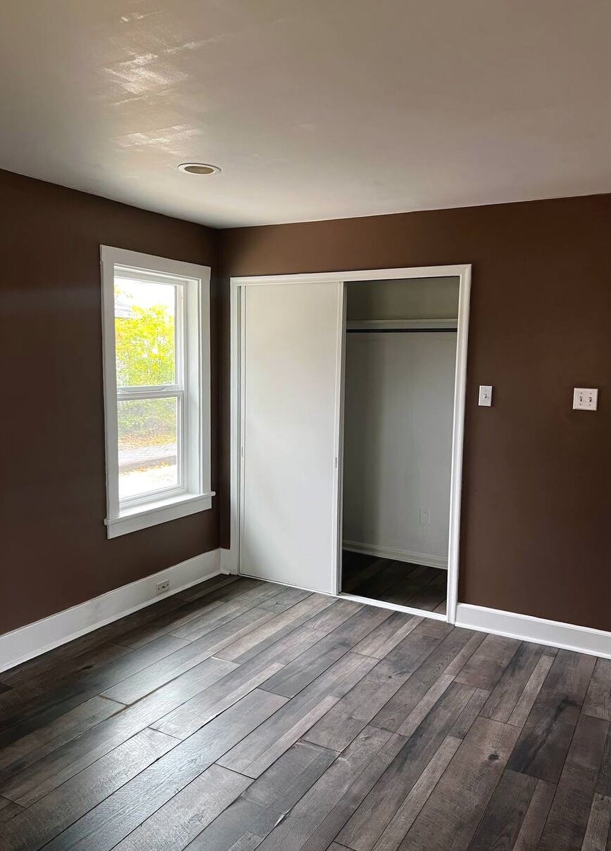 Second private room with a built-in closet, window and wide-plank flooring
