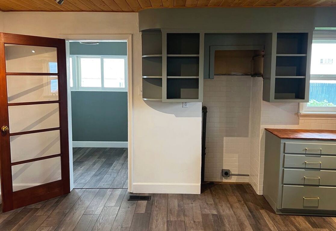 Kitchen and break area with sage cabinetry, butcher-block counter, subway tile backsplash and a wood-plank ceiling