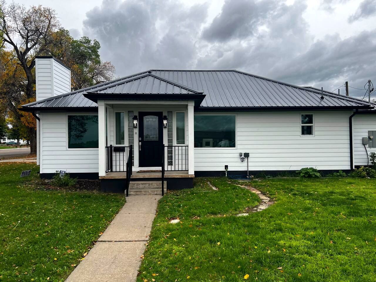 Front elevation at 90 S 400 W, Vernal UT — white lap siding, standing-seam metal roof, covered porch and deep front lawn