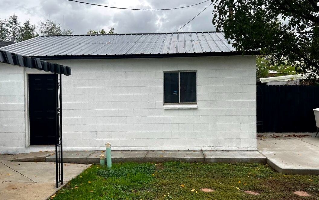 Detached block garage with metal roof and concrete apron — half included in the lease