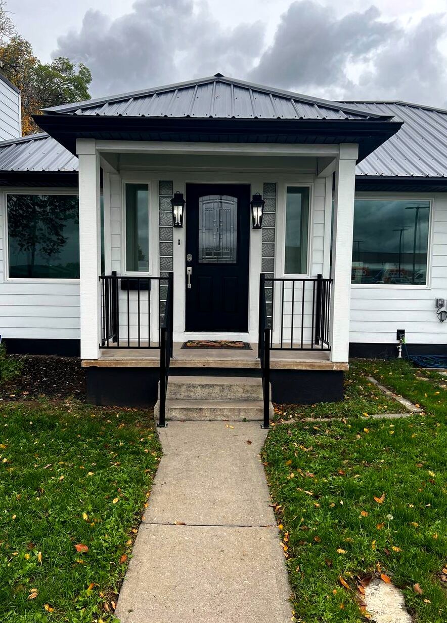 Covered entry porch with leaded-glass door, carriage lanterns and decorative glass-block sidelights